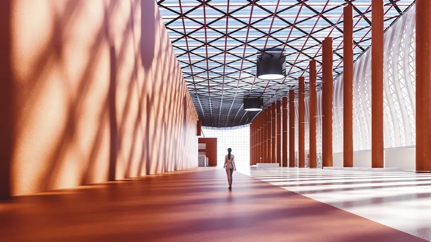 An artistic shot of a woman walking through an orange mezzanine area with long shadows on the wall.