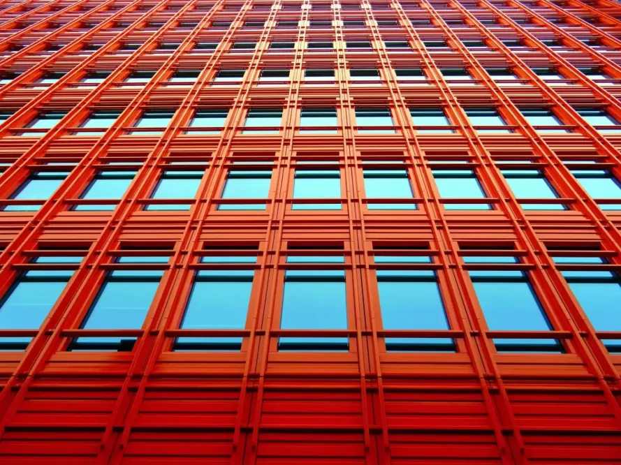 View looking up at a tall red building with windows